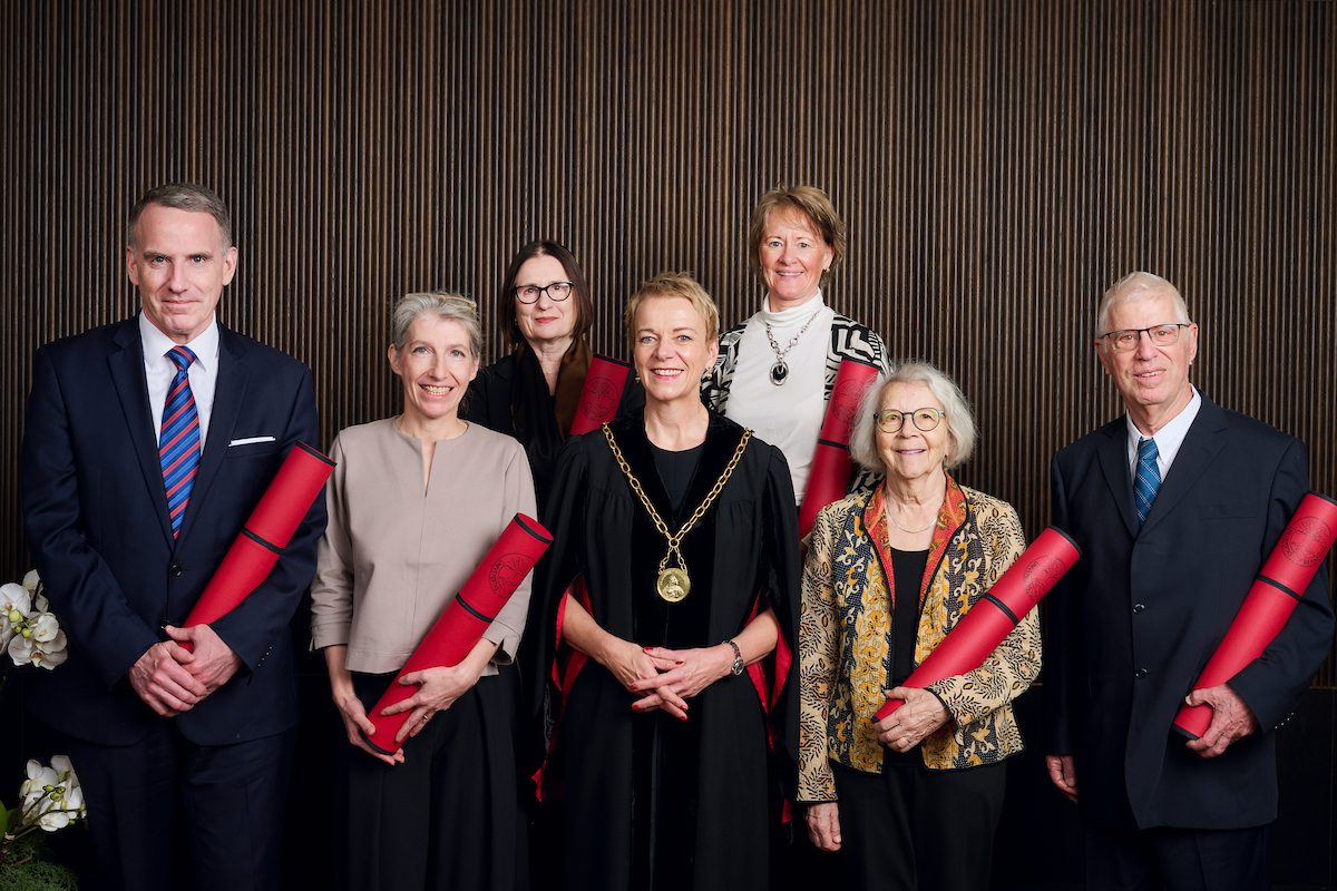 Am 190. Dies academicus der Universität Bern erhielten sieben Persönlichkeiten ein Ehrendoktorat (mit roter Diplomrolle). V.l.n.r.: Edward Glaeser, Christiane Wendehorst, Irina Scherbakowa, Virginia Richter (Rektorin), Cindy Adams, Simone E. Volet, Amihai Mazar. Auf dem Bild fehlt: Kuno Lauener © Universität Bern, Bild: Manu Friederich